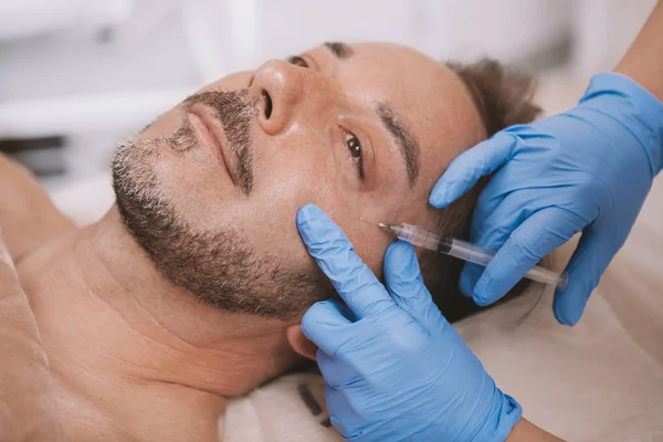 Mature man getting facial filler injections