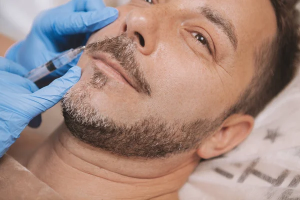 Bearded handsome mature man getting anti-wrinkle treatment — Foto de Stock