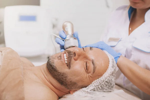 Mid-aged male client enjoying hardware cosmetology treatment — Fotografia de Stock