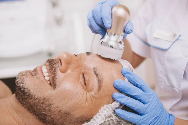 Mid-aged male client enjoying hardware cosmetology treatment — Stock Photo, Image