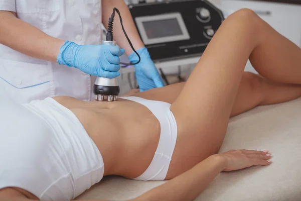 Beautiful woman getting rf-lifting treatment by cosmetologist