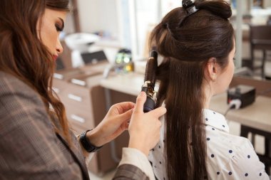 Güzellik salonunda tanınmayan bir kadının kıvırcık saç stili.