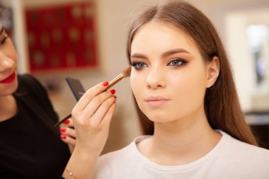 Profesyonel makyöz moda gösterisi için model hazırlıyor.