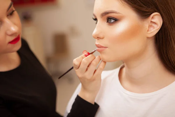 クロッププロフィールショットのA豪華な女性取得彼女の唇とともに口紅でプロの化粧アーティスト — ストック写真