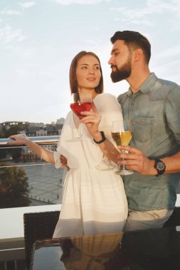 Güzel bir kadının bar terasında yakışıklı erkek arkadaşıyla sarmaş dolaş görüntüsü.