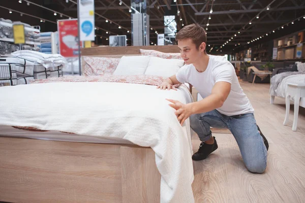 Foto Completa Joven Guapo Eligiendo Una Cama Nueva Para Comprar — Foto de Stock