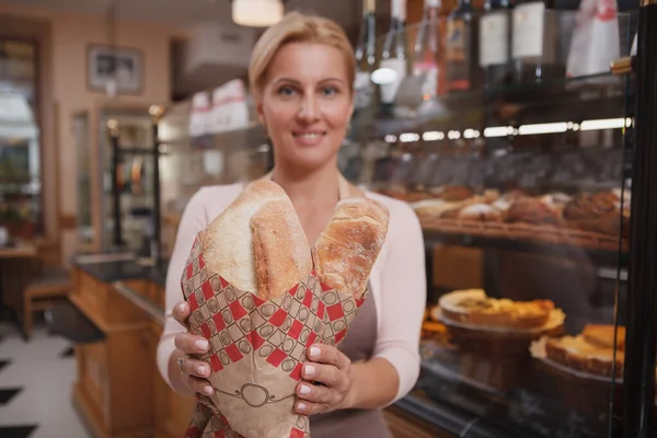 女性のパン職人の手で焼きたてのパンに焦点を当てる — ストック写真