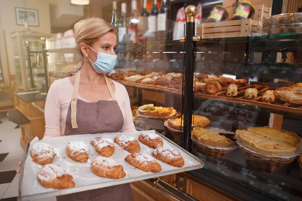 Female Baker Carrying Croissants Trey Wearing Medical Face Mask Working — Stock Photo, Image