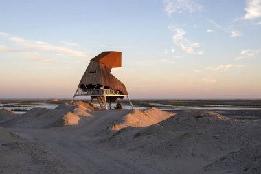 Kuş gözlem kulesi günbatımı, akşam içinde dunes içinde bulunan Markermeer, Hollanda'da bir göl yeni topraklardaki.