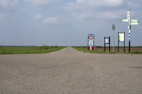 自転車レーンと多く署名地平線でオランダの平らな地形に干拓地白い雲と青い空 — ストック写真