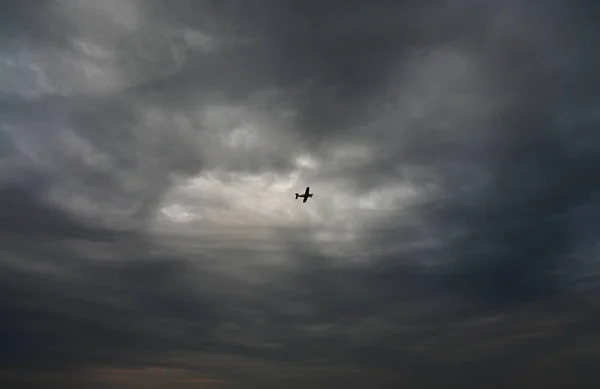 The plane flies in the stormy sky