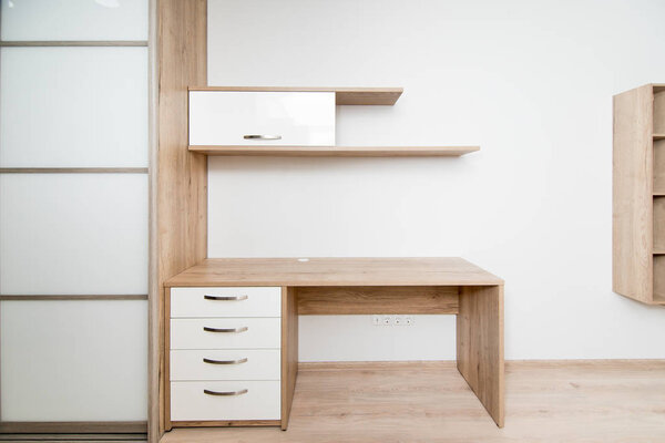 Фотография деревянного стола и полки в номере отеля
