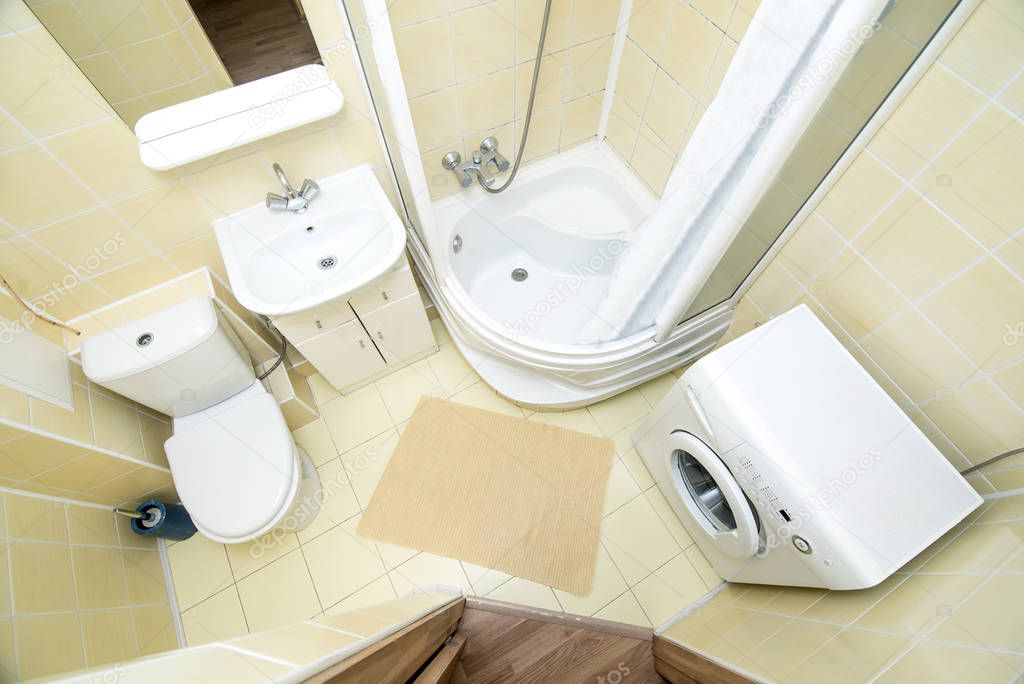 The photo of the light white bathroom with household appliances the top view