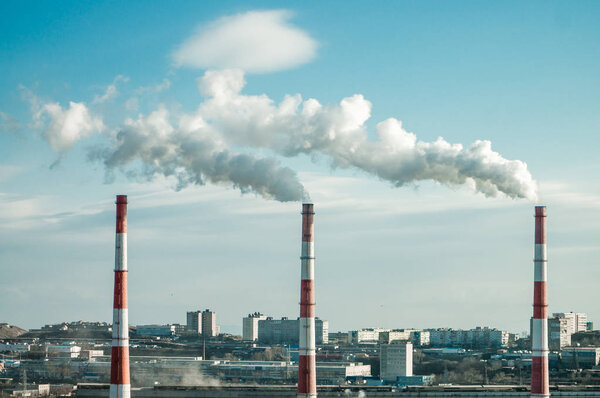 The photo of the platform with high pipes from which goes smoke