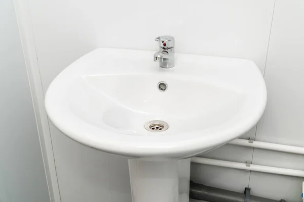 Белая раковина с краном в ванной комнате — стоковое фото