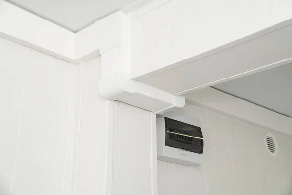 Protector eléctrico de plástico blanco en una pared blanca — Foto de Stock
