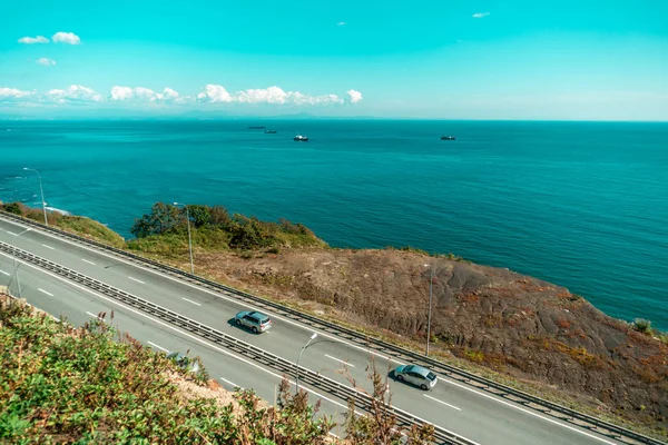 Väg vid havet med passerande bilar — Stockfoto