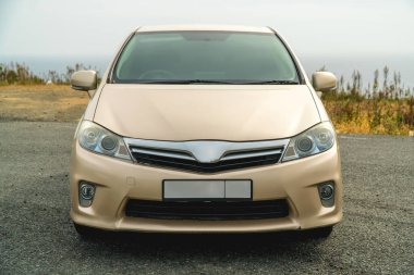 Sokakta duran altın renkli bir arabanın fotoğrafı.