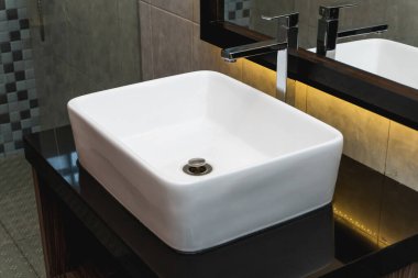 Banyoda seramik lavabo ve ayna fotoğrafı.