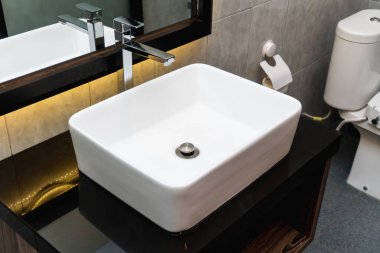 Banyoda seramik lavabo ve ayna fotoğrafı.