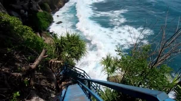 海と岩の見える高い山の崖への古い木製の階段上の適切な人の一人称ビデオ — ストック動画