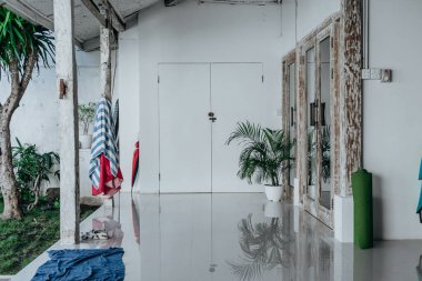 Cam pencereli ahşap kapılı beyaz bir odanın fotoğrafı.