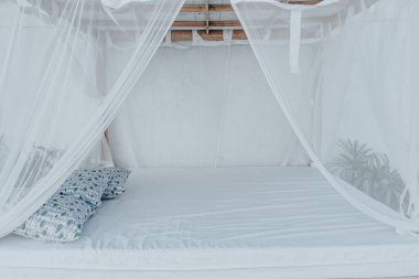 Dışarıdaki sivrisinek ızgarasının altında ahşap yataklı bir çardağın parlak fotoğrafı.