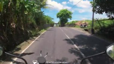 Asfalt yolda motosiklet sürmek Bali 'deki ilk insan