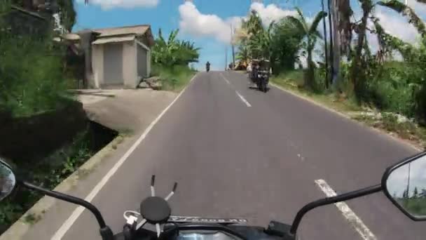 バリの最初の人で舗装道路上のオートバイに乗る — ストック動画