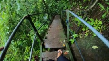 Eski metal merdivenlerde kayalık manzaralı yüksek bir dağdaki uçuruma uygun birinin videosu.