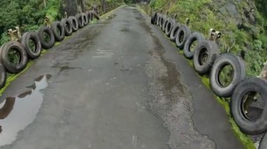 Bir ormanın yüksek bir dağın tepesindeki kayalık ve yeşil ağaçlarla ilgili birinci şahıs videosu.