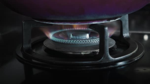 キッチンのクローズアップで青と赤の燃える炎と黒のガスストーブの4Kビデオ — ストック動画