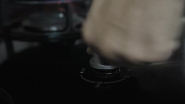 Mutfakta mavi ve kırmızı alevli siyah bir gaz sobasının 4K videosu.