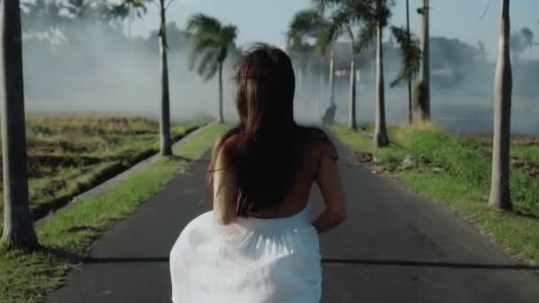 Wideo Piękną Młodą Brunetką Biegnącą Pustej Drodze Palmami Bali — Wideo stockowe