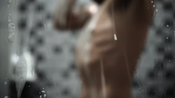 Młody Mężczyzna Biorąc Prysznic Łazience Widok Przez Lustro Zamazanym Tle — Wideo stockowe