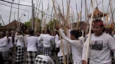 Desa Munggu, Kabupaten Badung, Bali, Endonezya - 29 Şubat 2020: Seremoni Mekotek, Hindular tarafından yüzyıllardır Bali 'de ilan edilen bir miras. Erkeklerin tuttuğu uzun sopalı bir ayin..