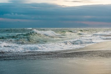 Endonezya 'daki Bali adasında kumsaldaki kayalara çarpan büyük dalgaların fotoğrafı