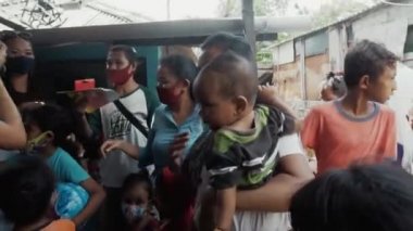 Benoa, Kuta, Kabupaten Badung, Bali, Endonezya - 8 Temmuz 2020: Yüzlerinde maskeli insanlar ve çocukların olduğu Endonezya 'daki küçük bir köyün videosu