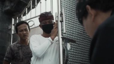 Benoa, Kuta, Kabupaten Badung, Bali, Endonezya - 8 Temmuz 2020: Endonezya 'da maskeli insanların olduğu küçük bir köyün videosu