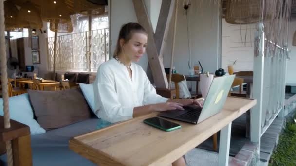 熱帯のカフェでノートパソコンの後ろで働いていました — ストック動画