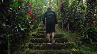 Kayalık manzaralı yüksek bir dağdaki uçuruma giden eski bir kaya merdivenindeki uygun kişinin birinci şahıs videosu.