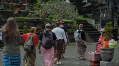 Pampatan, Rendang, Karangasem Regancy, Bali, Endonezya - 18 Temmuz 2020: Bali adasında antik taş binaların bulunduğu kutsal bir yerde yürüyen insanların videosu