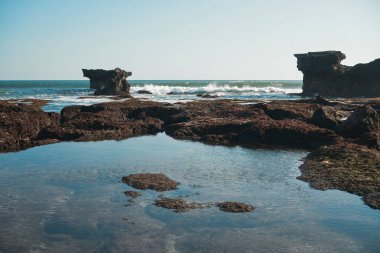 Deniz altı renkli bir geminin fotoğrafı. Deniz suyunda yüksek uçurumları olan ve gökyüzünün yansıması olan bir gemi.
