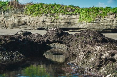 Deniz altı renkli bir geminin fotoğrafı. Deniz suyunda yüksek uçurumları olan ve gökyüzünün yansıması olan bir gemi.