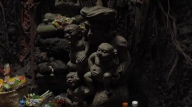 Mawar, Punggul, Kabupetan Badung, Bali, Endonezya - 28 Temmuz 2020: güçlü gölgeleri olan karanlık bir mağarada antik insan heykelleri için dini bir yer