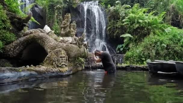 Mawar Pungul Kabupetan Badung Bali インドネシア 2020年7月28日 滝を背景にしていない人々の像と石と洗浄とインドネシアの神聖な場所 — ストック動画