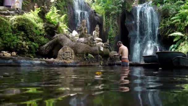 Mawar Pungul Kabupetan Badung Bali インドネシア 2020年7月28日 滝を背景にしていない人々の像と石と洗浄とインドネシアの神聖な場所 — ストック動画
