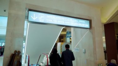 SEOUL, Güney Kore - 22 Mayıs 2019: Kore 'de halka açık bir yerde yürüyen merdivene sırtlarını dönmüş insanların videosu