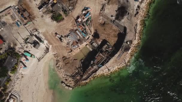 无人机拍摄的在海边沙滩码头上用蓝水建造一艘木船的视频 — 图库视频影像