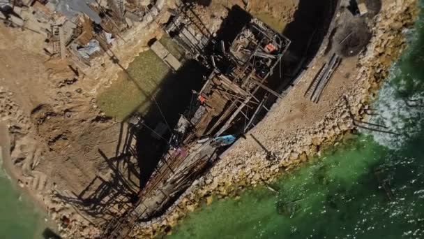 无人机拍摄的在海边沙滩码头上用蓝水建造一艘木船的视频 — 图库视频影像